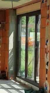 Unfertiger Innenraum mit Glas-Tür und Fenster im Bau