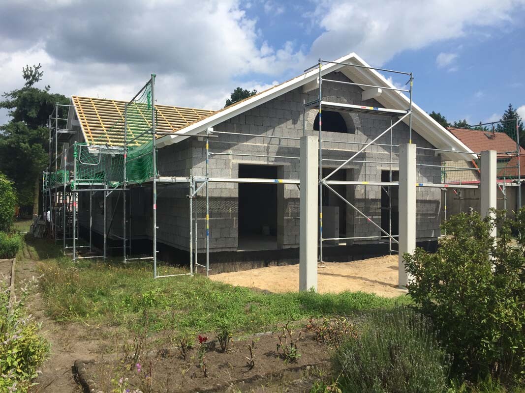 Unfertiges Einfamilienhaus aus Betonblocksteinen mit Gerüst und Dachstuhlbau