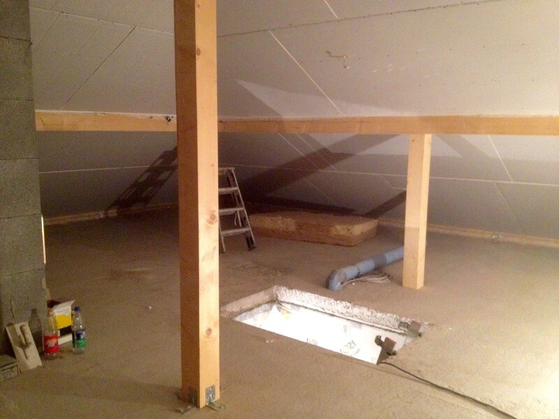 Unfertiger Dachboden im Bau mit Holzbalken, Leiter und offener Bodenausschnitt