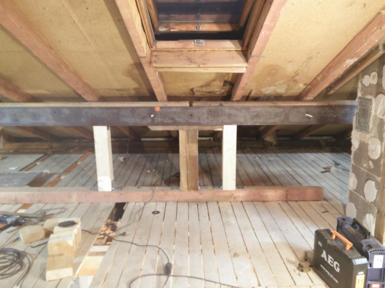 Dachboden-Rohbau mit Holzbalken, Querträger, Werkzeugen und AEG-Werkzeugkoffer rechts