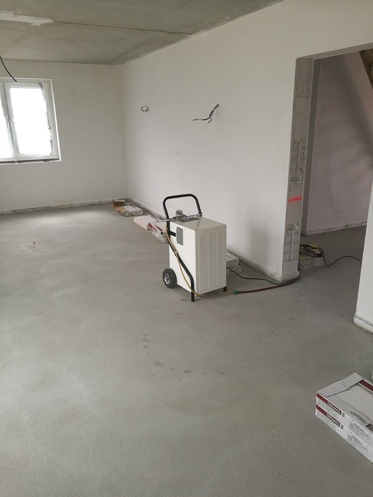 Unfertiger Innenraum eines Hauses im Bau mit Heizgerät auf Rädern