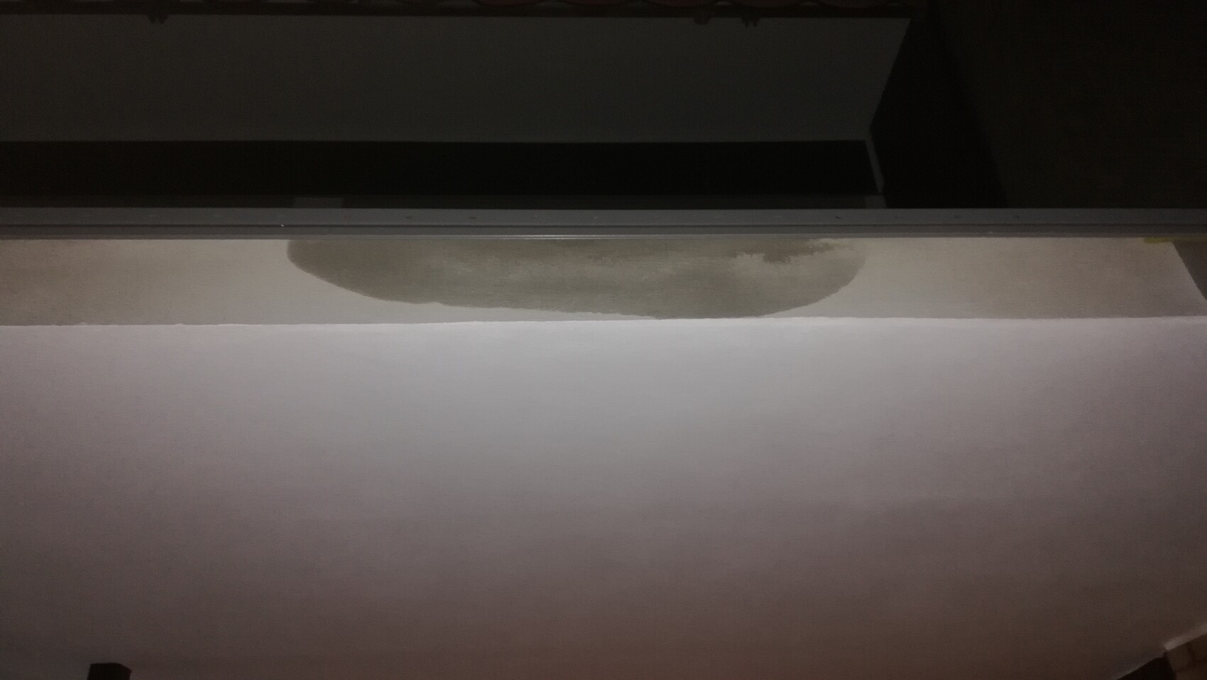 Weißer Tisch oder Papier mit braunem Kreisfleck, dunkler Hintergrund oben.