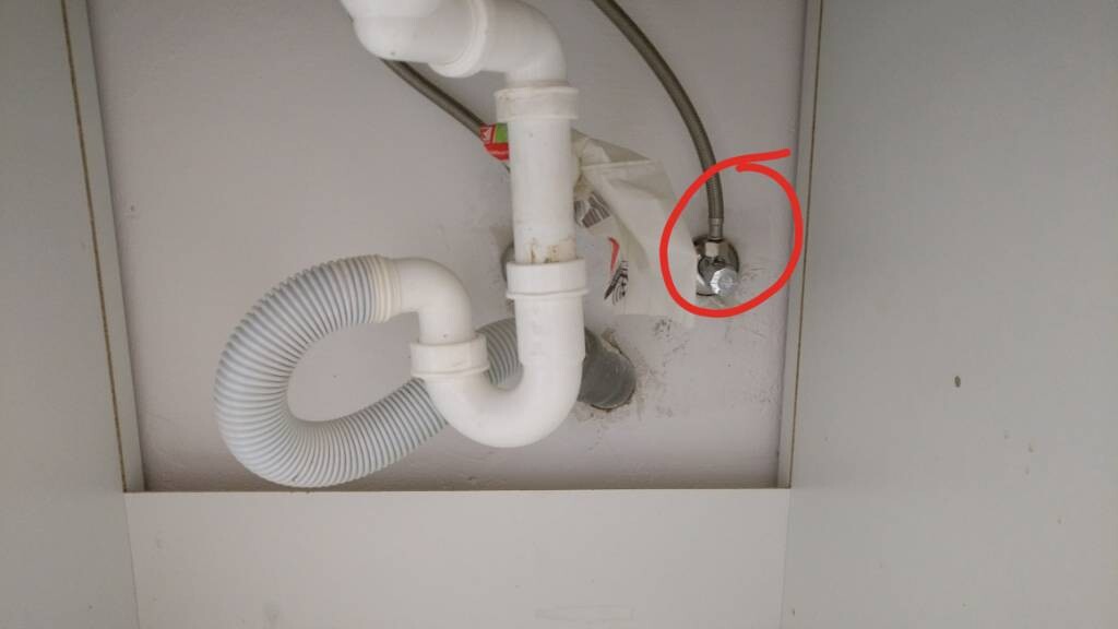 Unter dem Waschbecken sichtbares Abflussrohr, Siphon und Rohrverbindungen