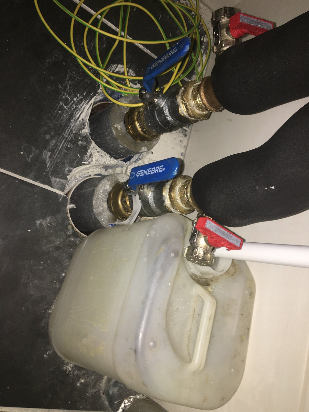 Unter dem Spülbecken: zwei blaue Absperrventile, Messingfittings, grüne Kabel.