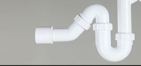 Weißes Siphon-Abflussrohr unter Waschbecken aus PVC