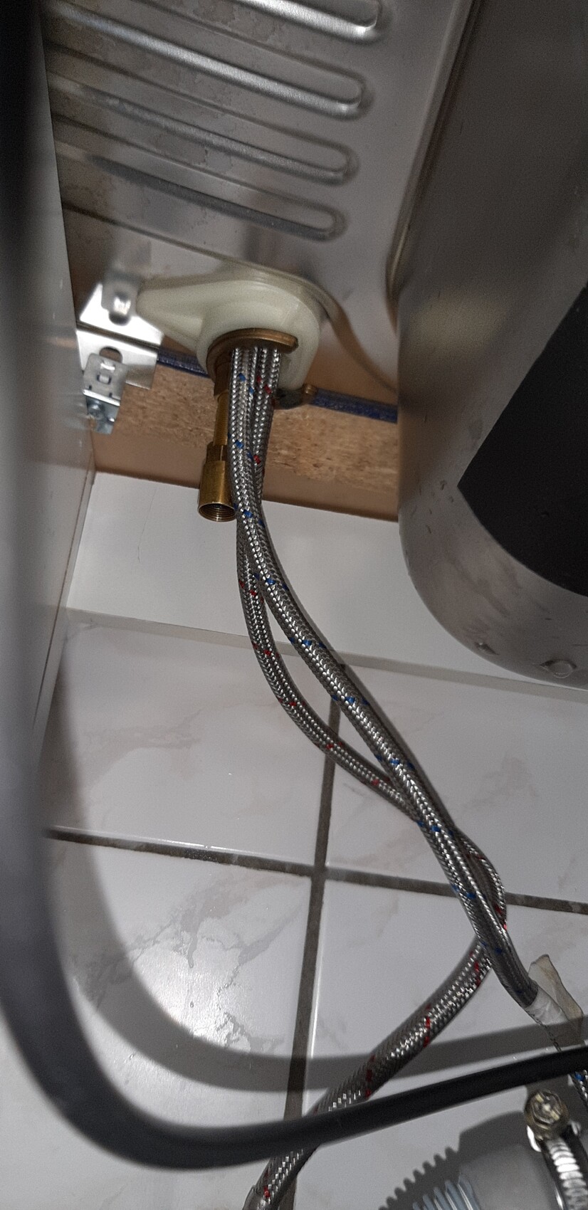Unter dem Waschmaschinen-Wasserschlauch aus Edelstahl-Spiralleitungen am Boden