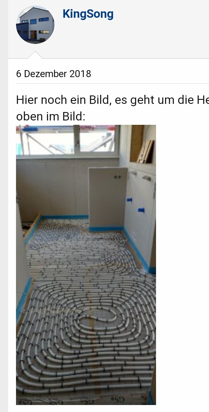Fußbodenheizung: Weiße Rohre spiralförmig auf dem Boden verlegt, Bauzimmer mit Fenster.