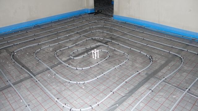 Unterbodenheizung Installation im Rohbau: Spiralverlegte Rohre auf Dämmunterlage