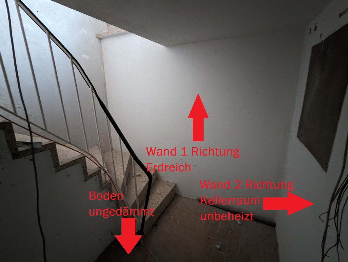 Kellertreppe mit ungedämmtem Boden und weißen Wänden; lose Kabel sichtbar.