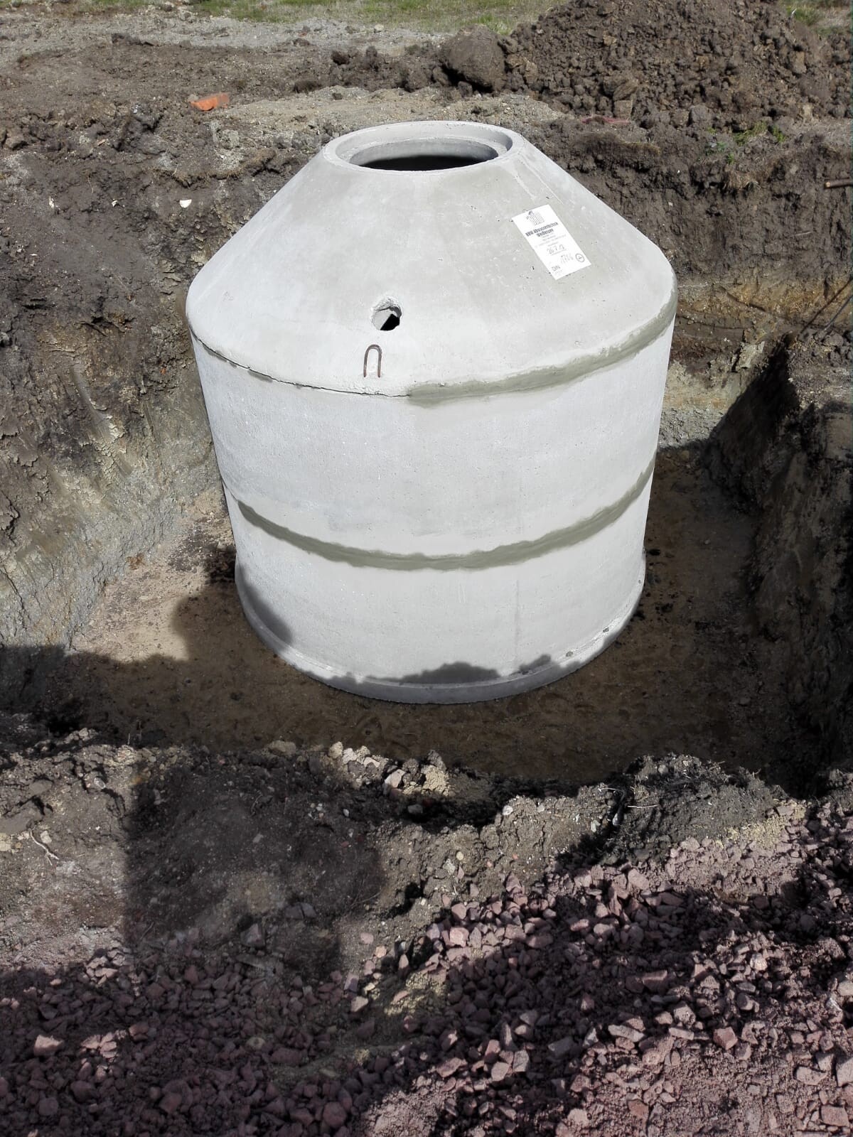 Großer grauer Betontank in einer Baugrube auf Baustelle