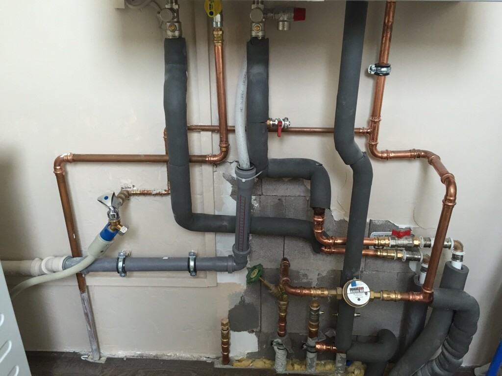 Unterputz-Rohrleitungen aus Kupfer und Dämmung mit Wasserzähler in Haustechnik-Installation