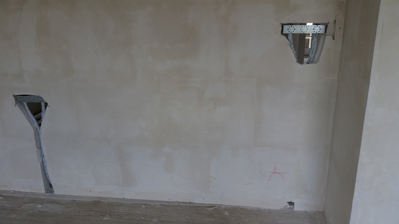 Unverputzte Wand im Innenausbau mit Kabelkanälen und Ausschnitten