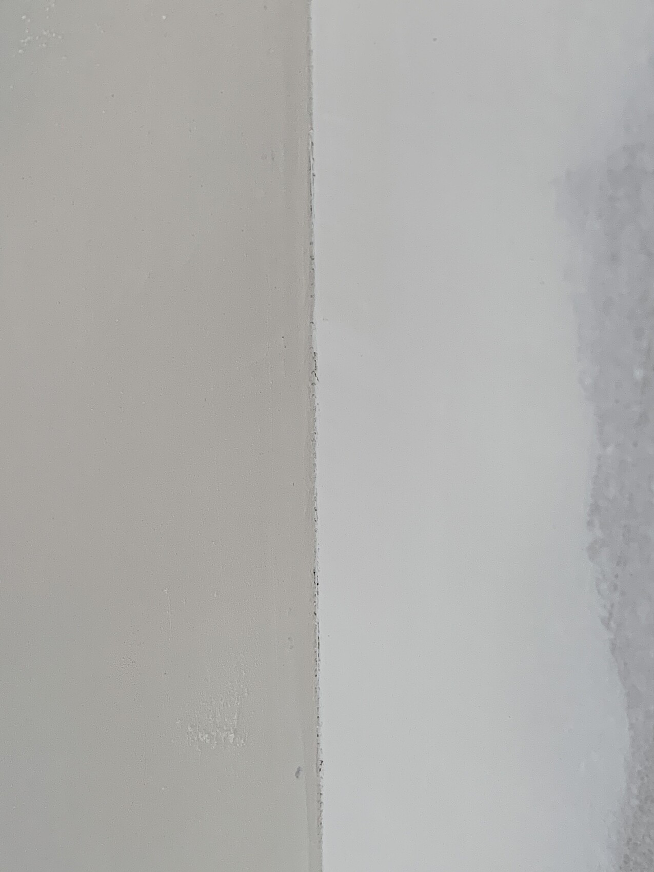 Wandfuge zwischen beige linker Fläche und weißer rechter Fläche.