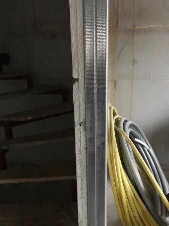 Blick in unfertigen Innenbereich eines Hauses mit Treppe, Metallständerwand und Kabelstrang