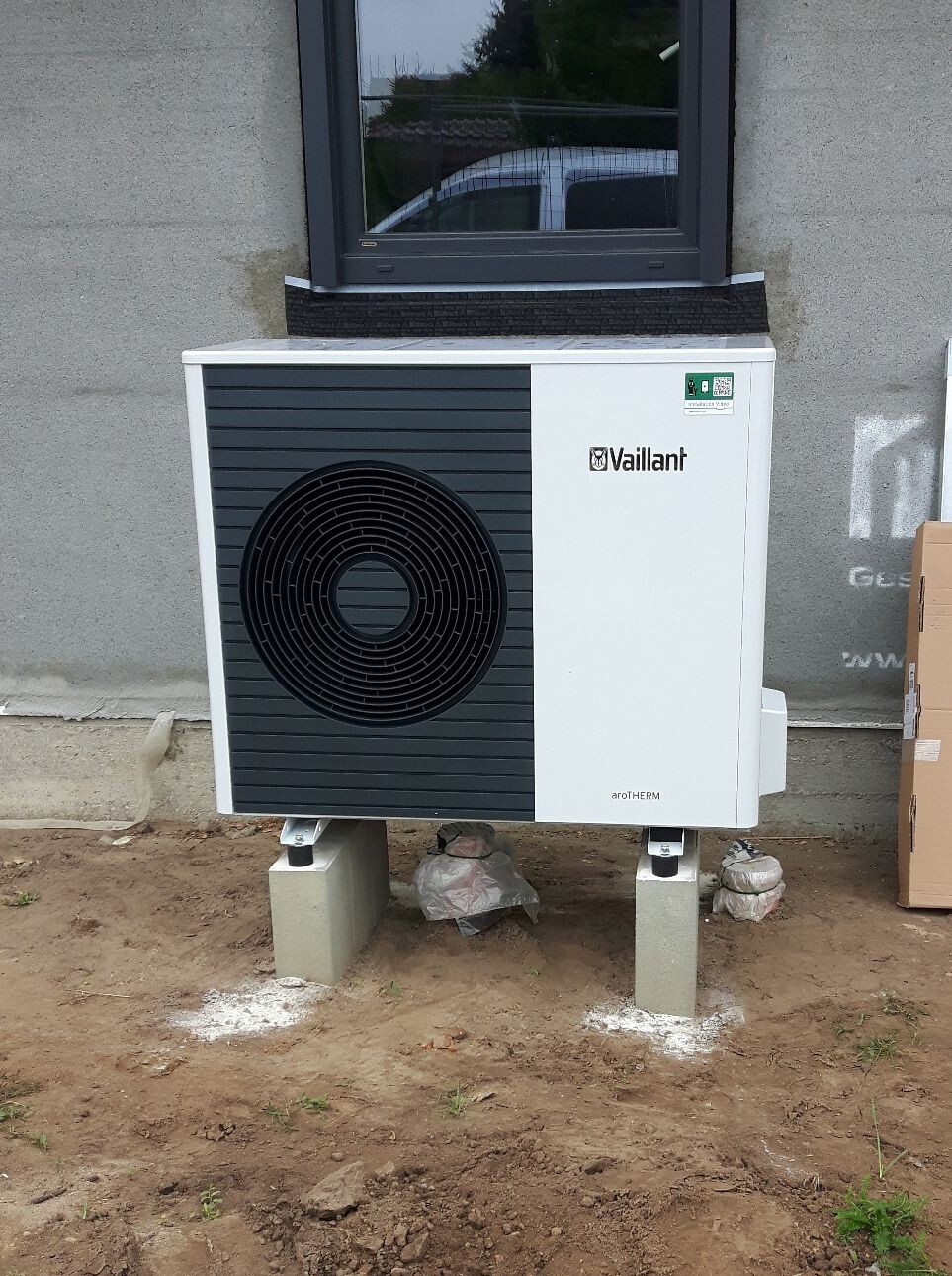 Außen-Einheit der Vaillant aroTHERM-Wärmepumpe auf Betonblöcken vor der Hauswand.