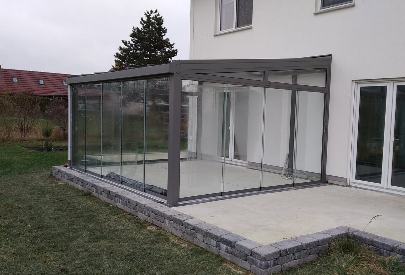 Verglasste Terrassenveranda am Wohnhaus mit Terrasse und Gartenbereich