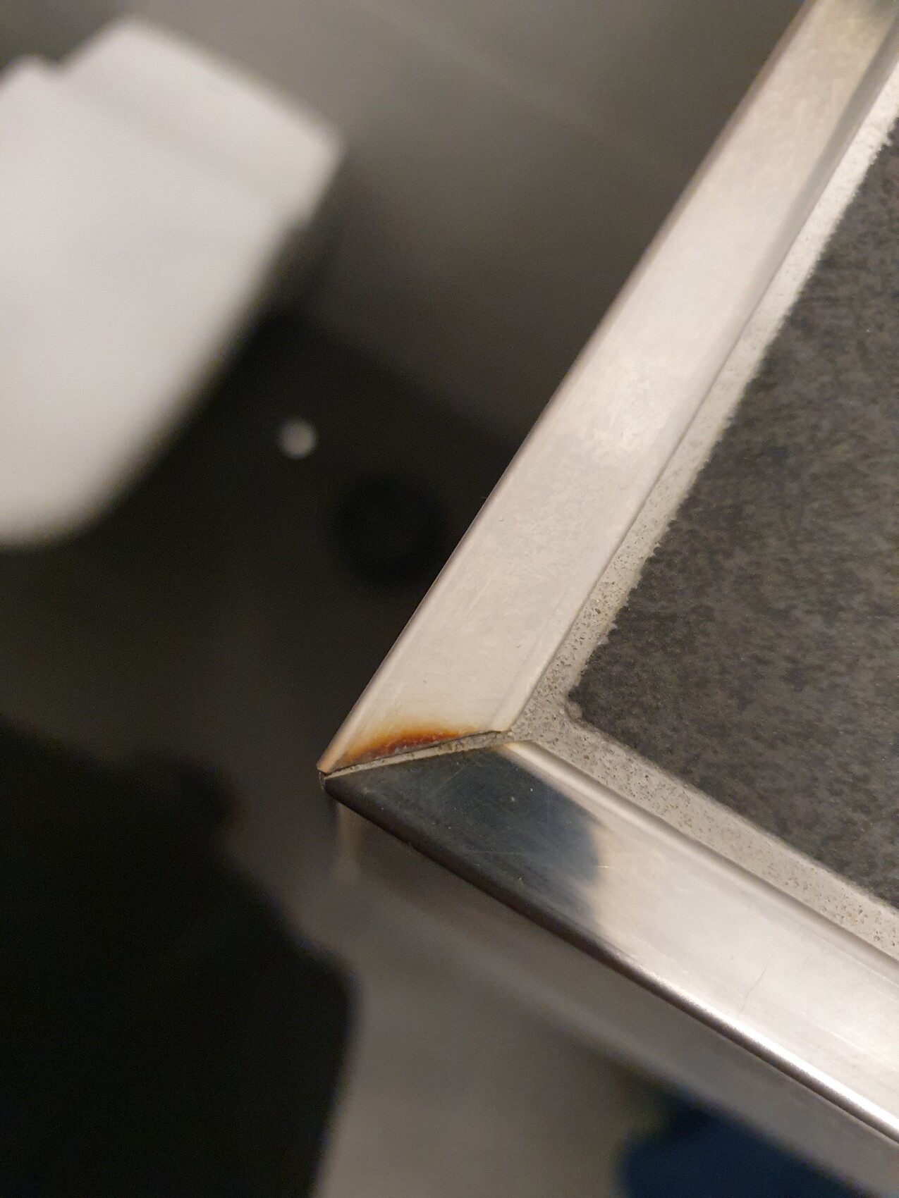 Nahaufnahme einer rostigen Ecke eines Metallrahmens.