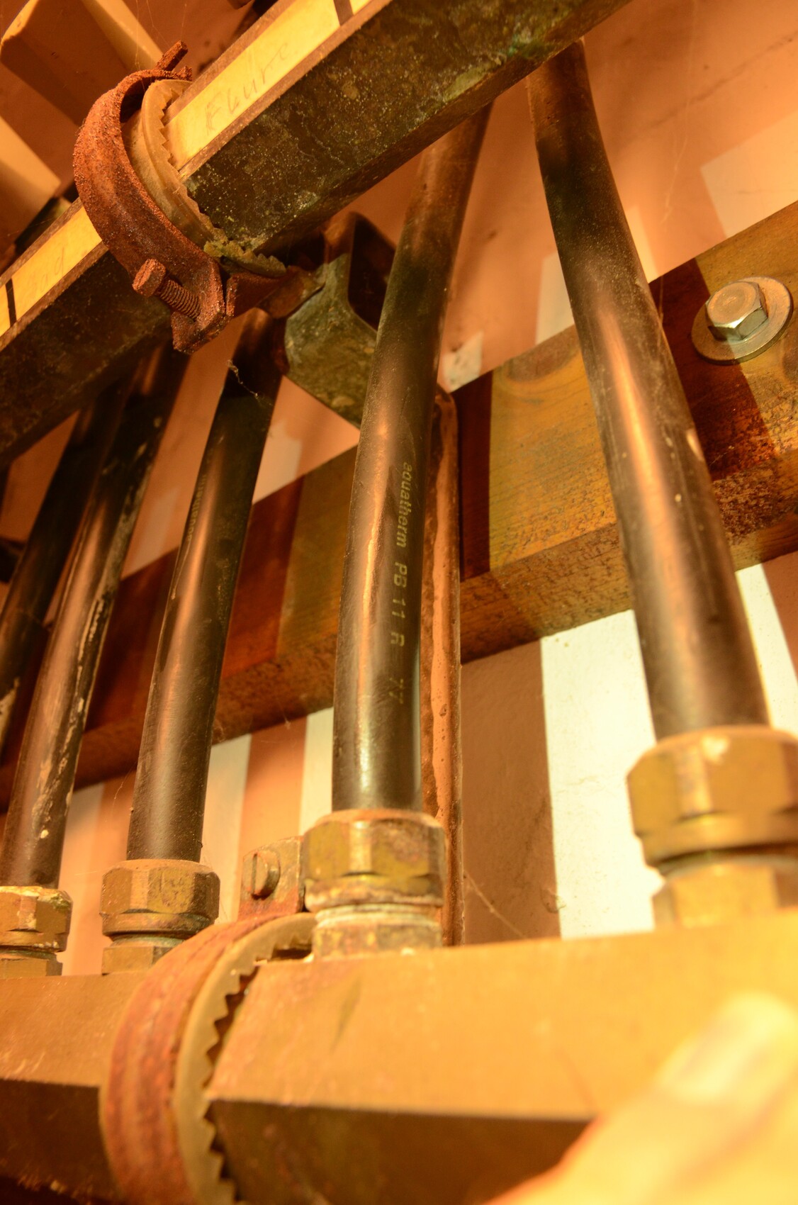 Nahaufnahme von rostigen Rohrleitungen, Muttern und Zahnrädern in einer industriellen Anlage