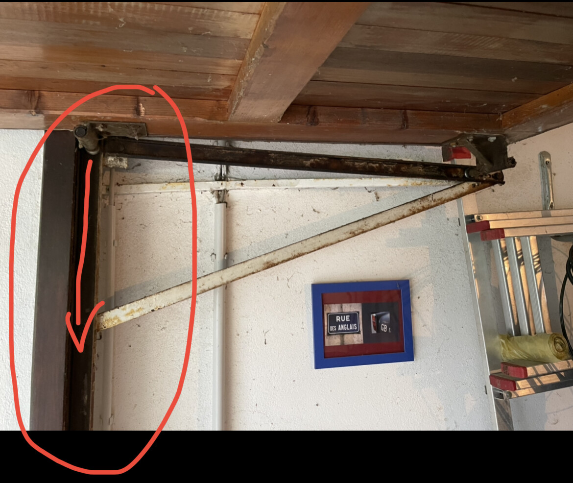 Rostige Metallkonstruktion unter der Decke: senkrechte Stange mit diagonaler Querstrebe.