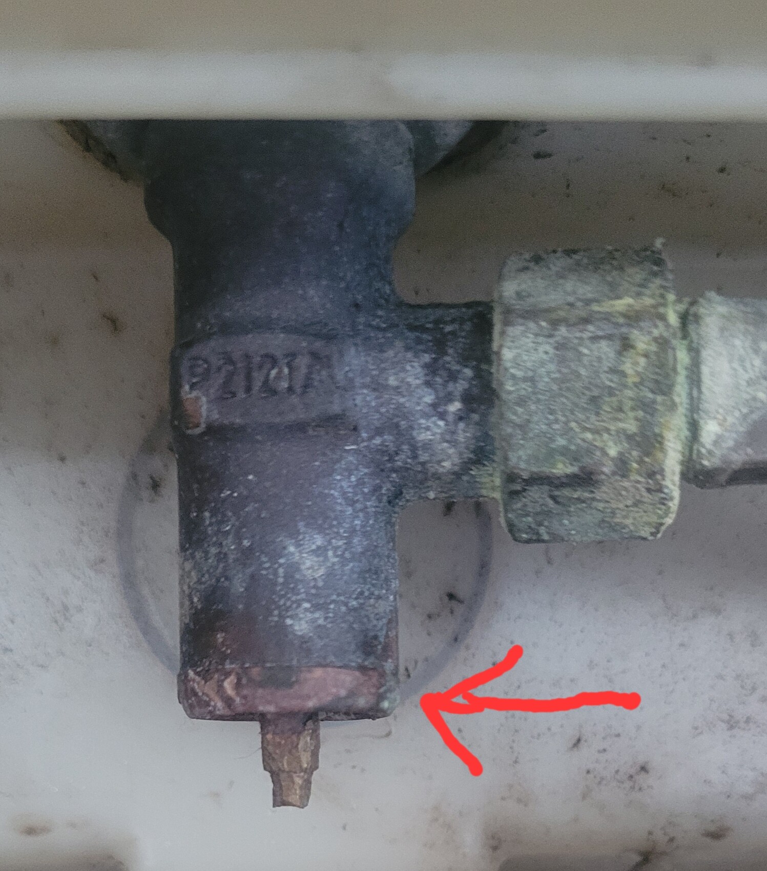 Verrostetes Wasserrohr mit T-Stück und grünlicher Korrosion.