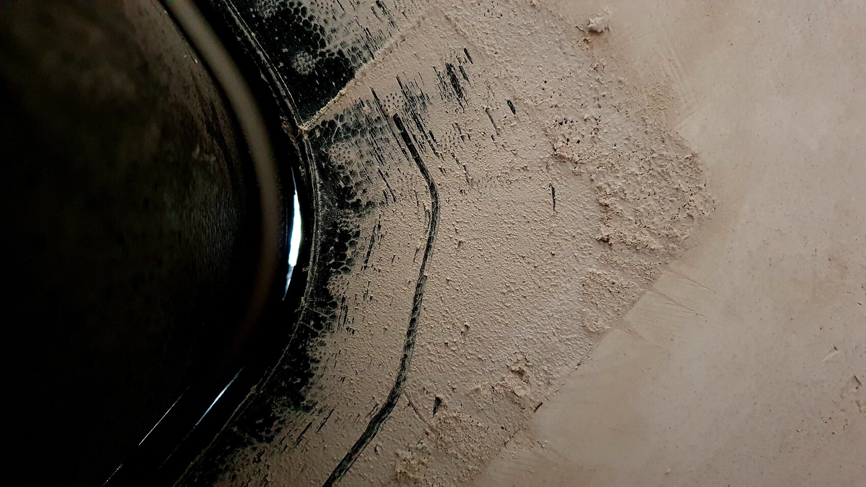 Nahaufnahme eines dunklen Kameraobjektivs mit Staub- und Sandablagerung