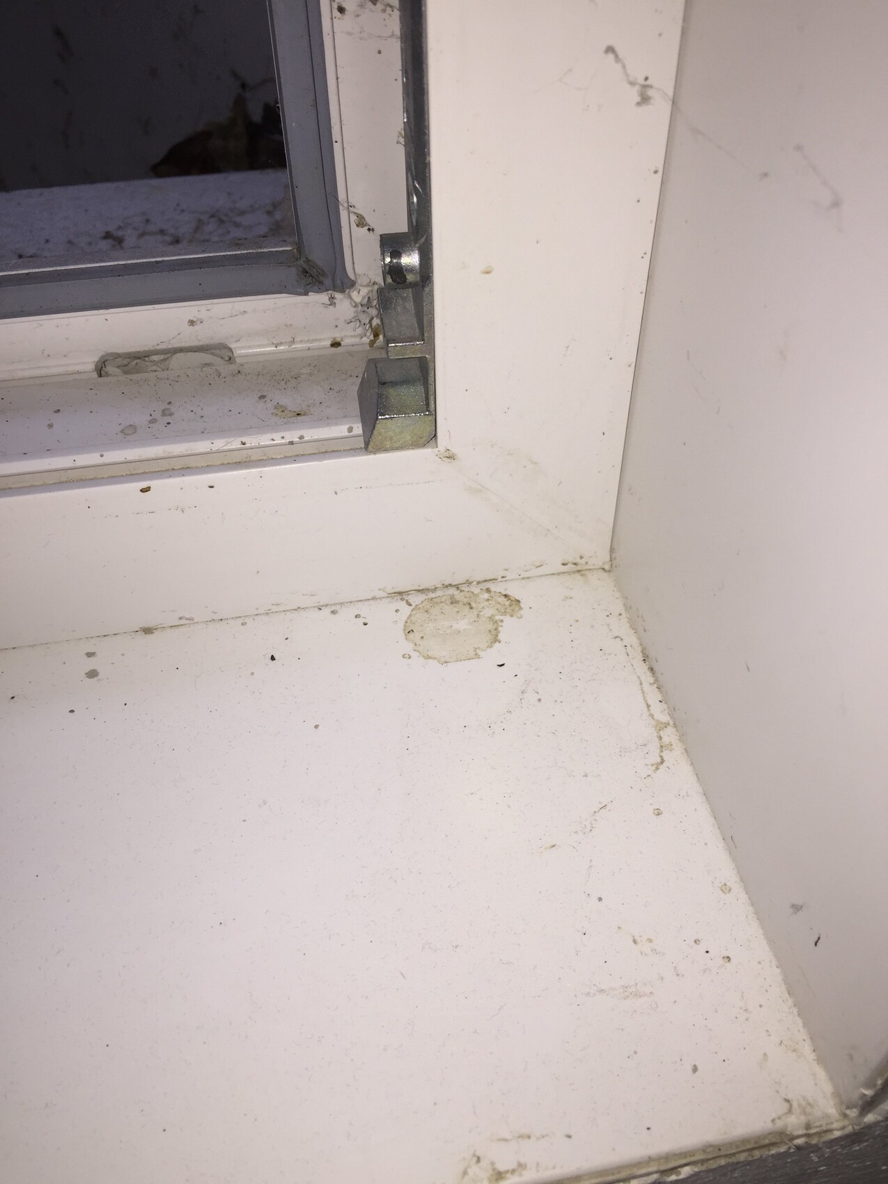 Verstaubter Fensterrahmen und Fensterbank-Ecke mit Verschluss.