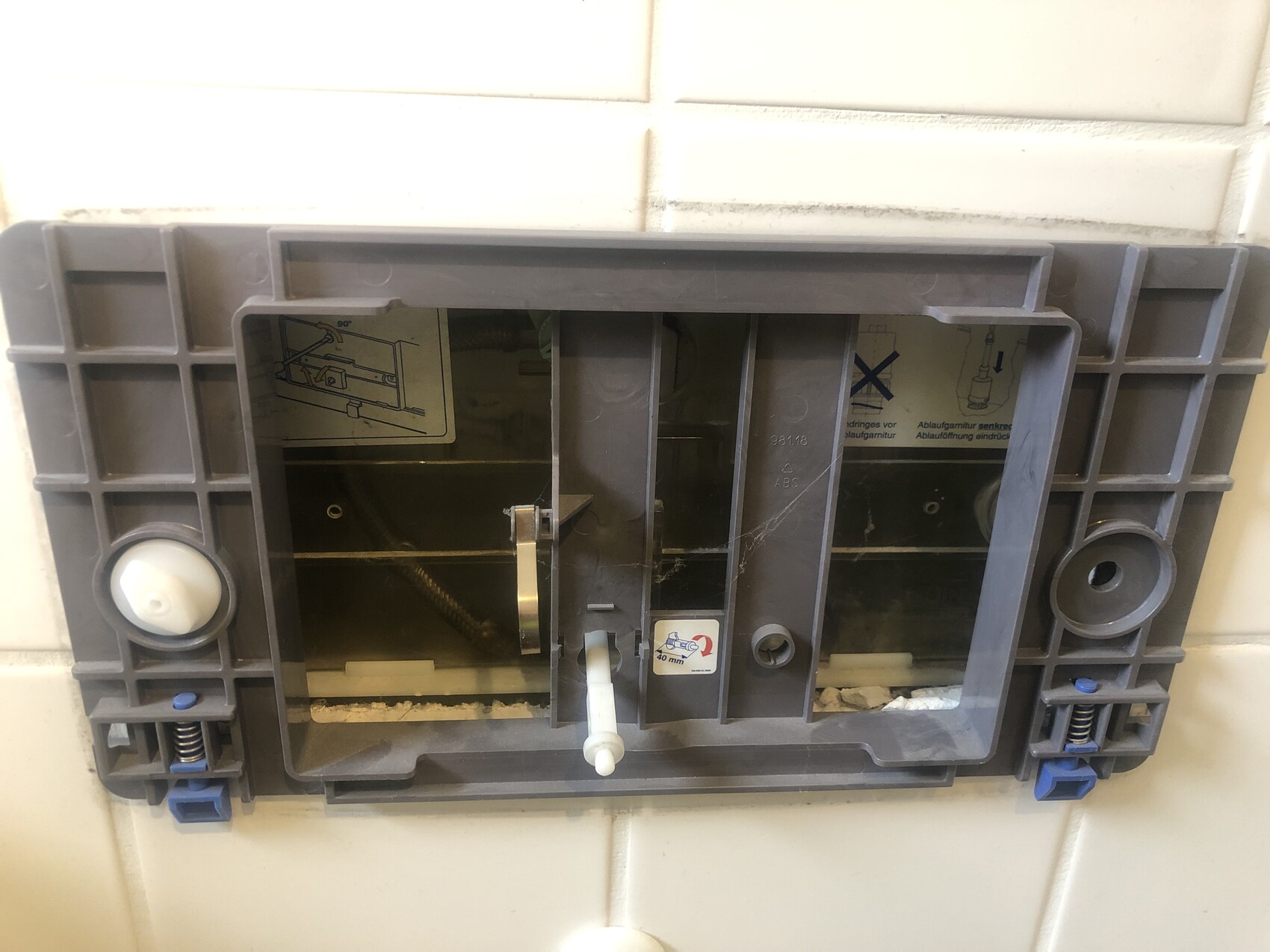 Versteckter Toilettenrahmen aus Kunststoff hinter Badfliesen, Installations- und Haltesystem sichtbar.