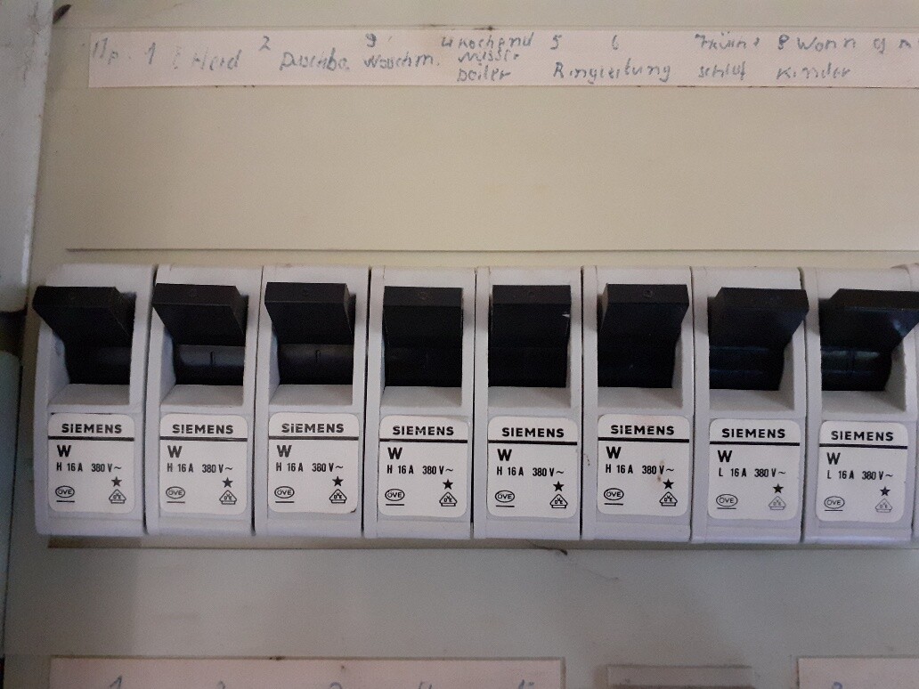 Mehrere Siemens-Sicherungsautomaten in einem Verteilerkasten mit schwarzen Kippschaltern.