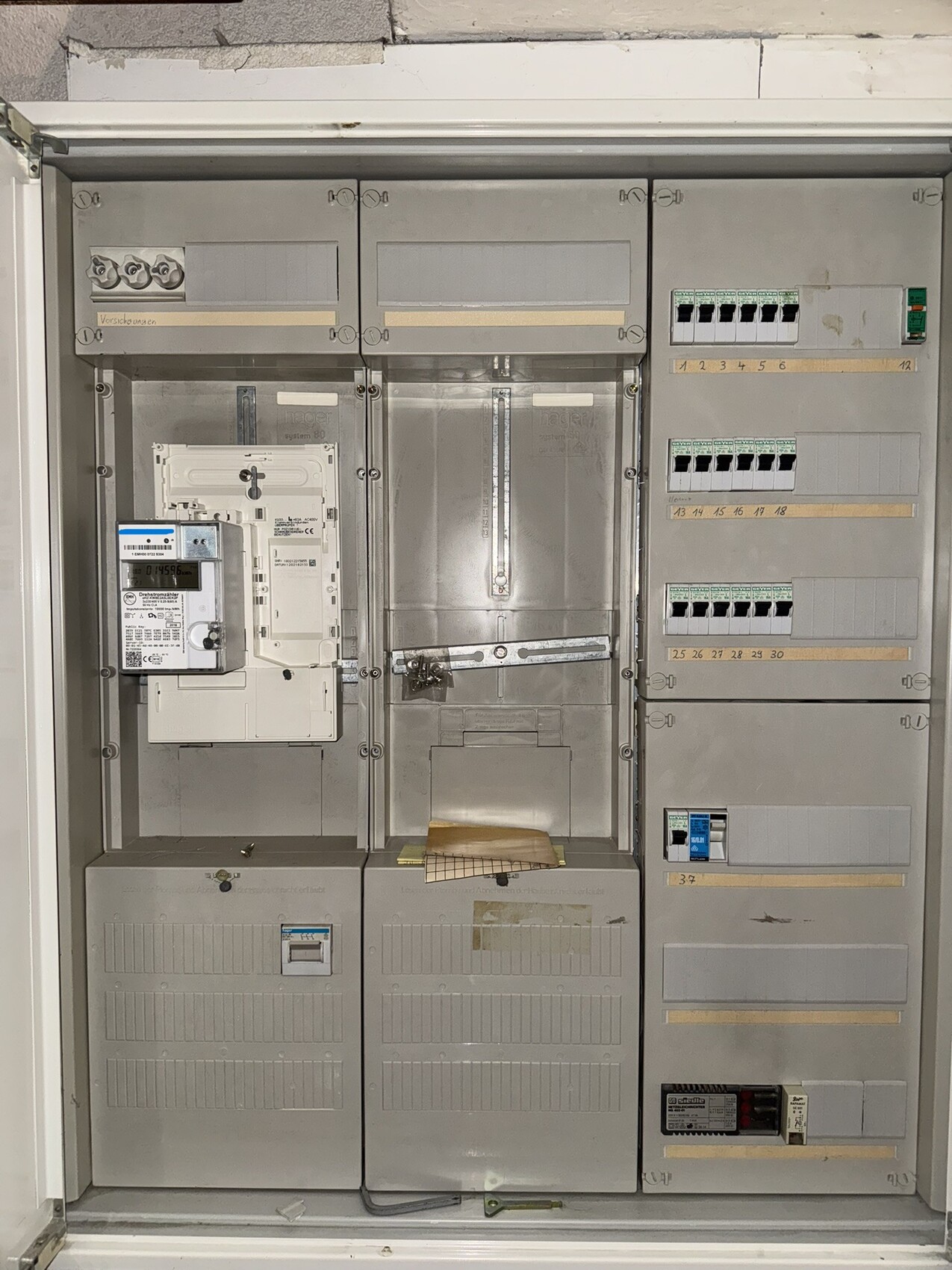Elektrischer Verteilerschrank mit Zähler und Sicherungen in Innenverteilkasten.