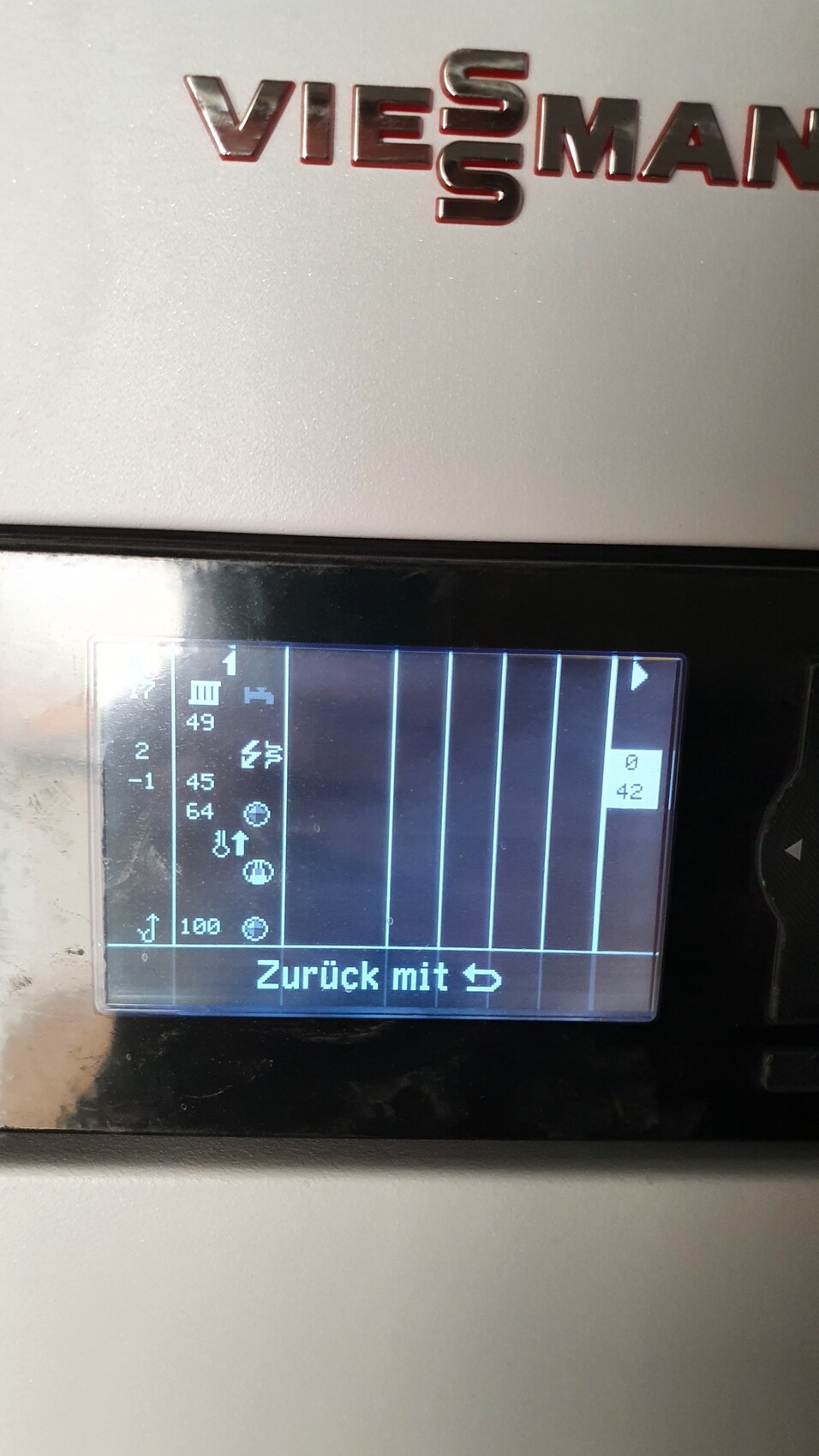 Silbernes Gehäuse mit kleinem blau leuchtendem Display, vertikale Linien und Text 'Zurück mit'.