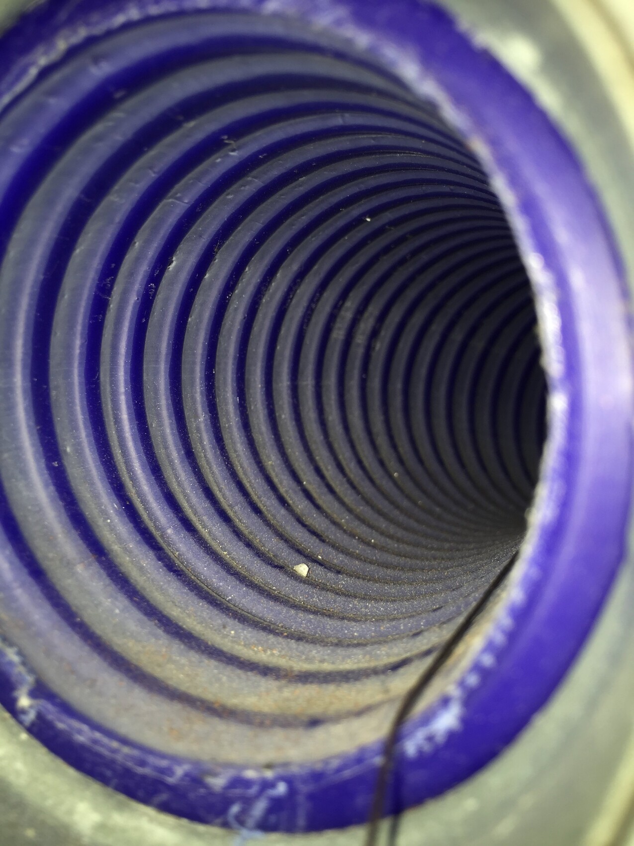Innenansicht eines violetten Rohrs mit spiralförmigen Rippen, Blick in den Hohlraum.