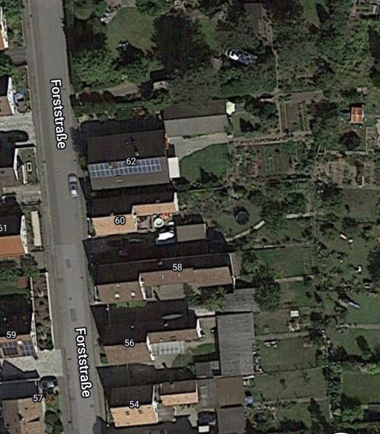 Luftbild der Forststraße: Häuserreihe mit Gärten, Dächern mit Solarpanelen (Nrn. 54–62).