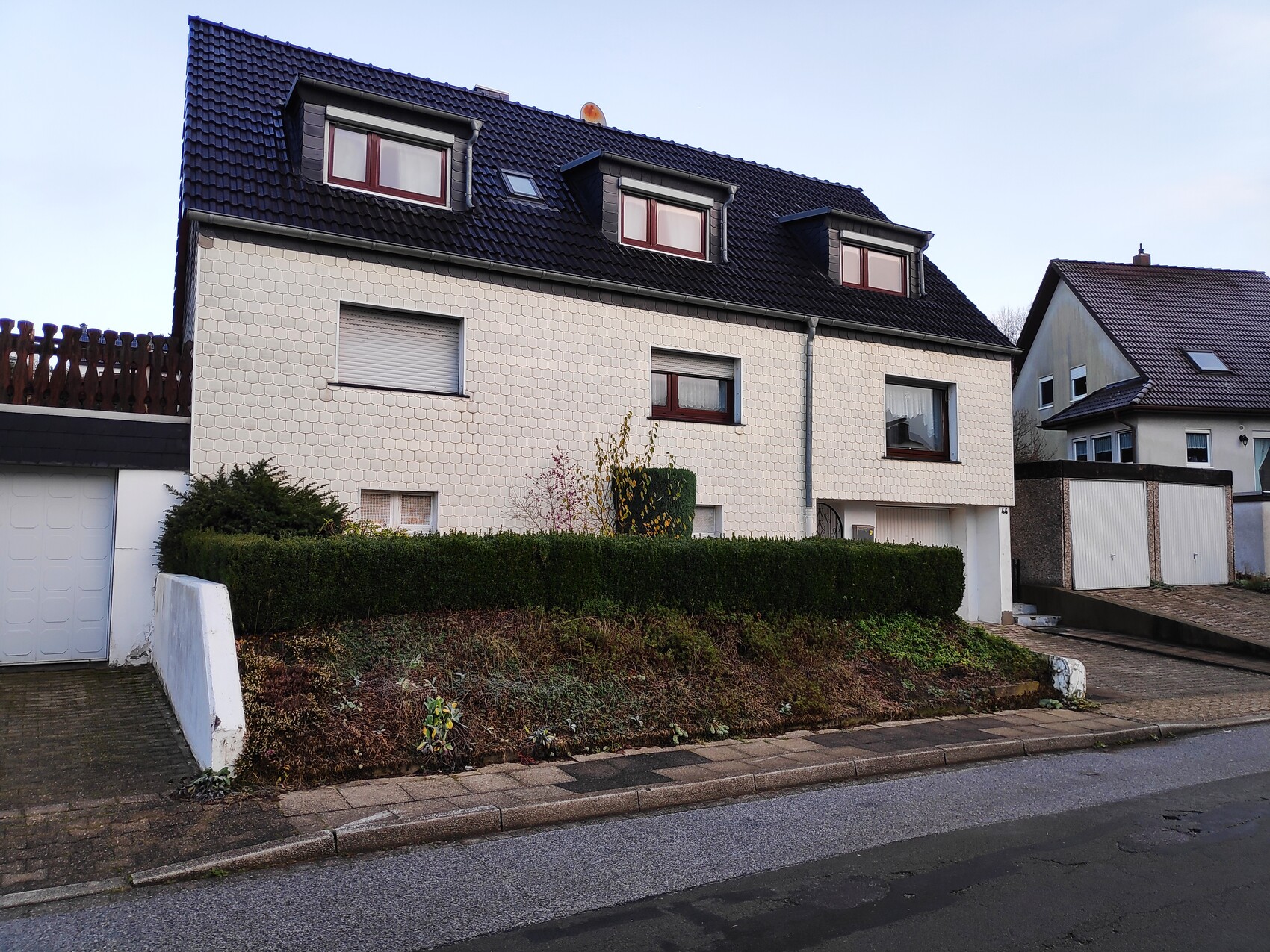 vorderansicht-helle-fassade-dachgauben-garten-hecke.jpg