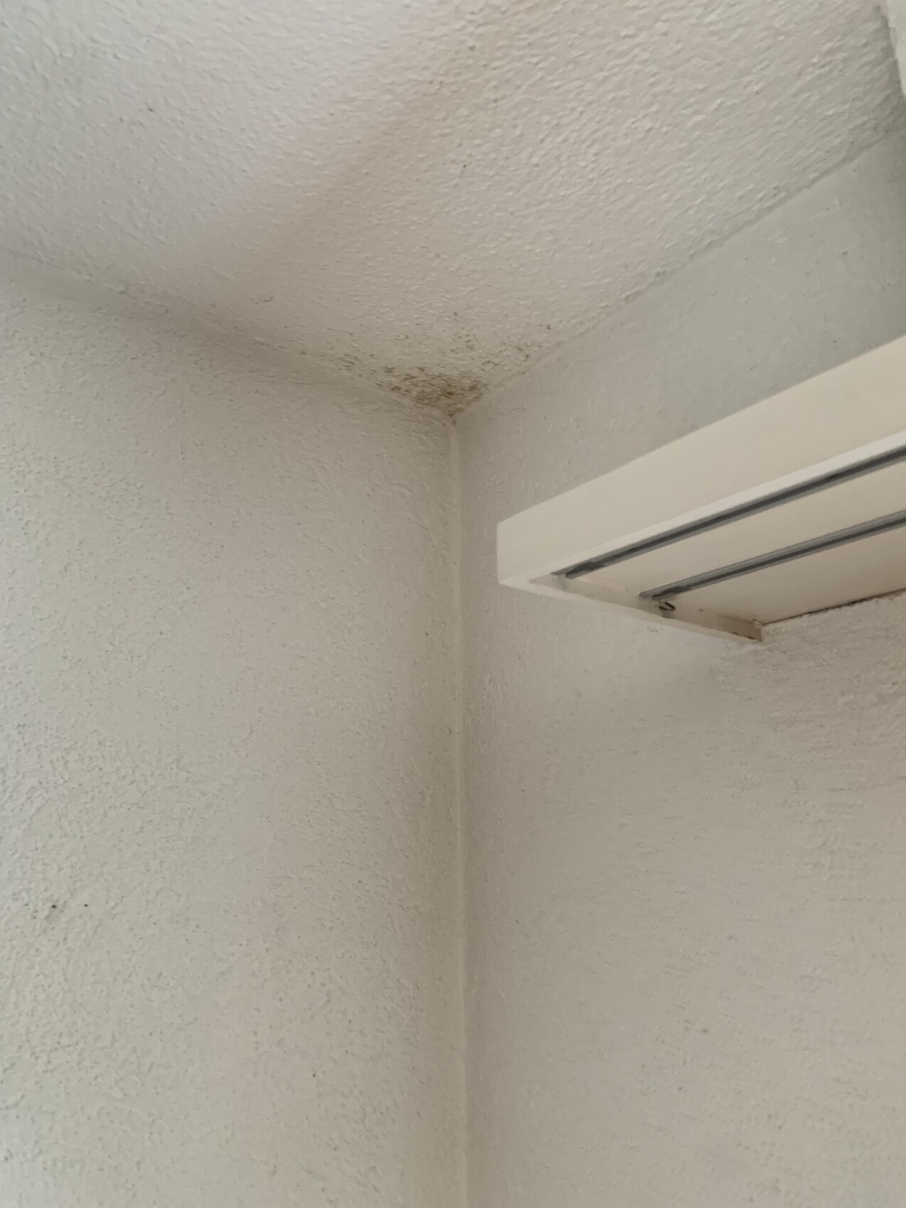 Weiße Innenwand Ecke mit Wandventil/Luftauslass und Feuchtigkeitsfleck