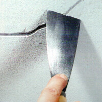 Hand spachtelt Putz an Wand beim Innenausbau