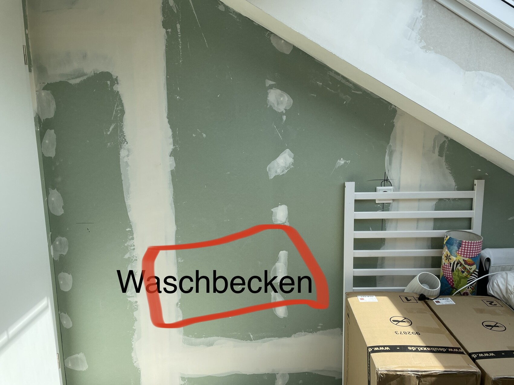 Renovierungsraum mit grüner Trockenbauwand; rote Umrandung markiert 'Waschbecken'