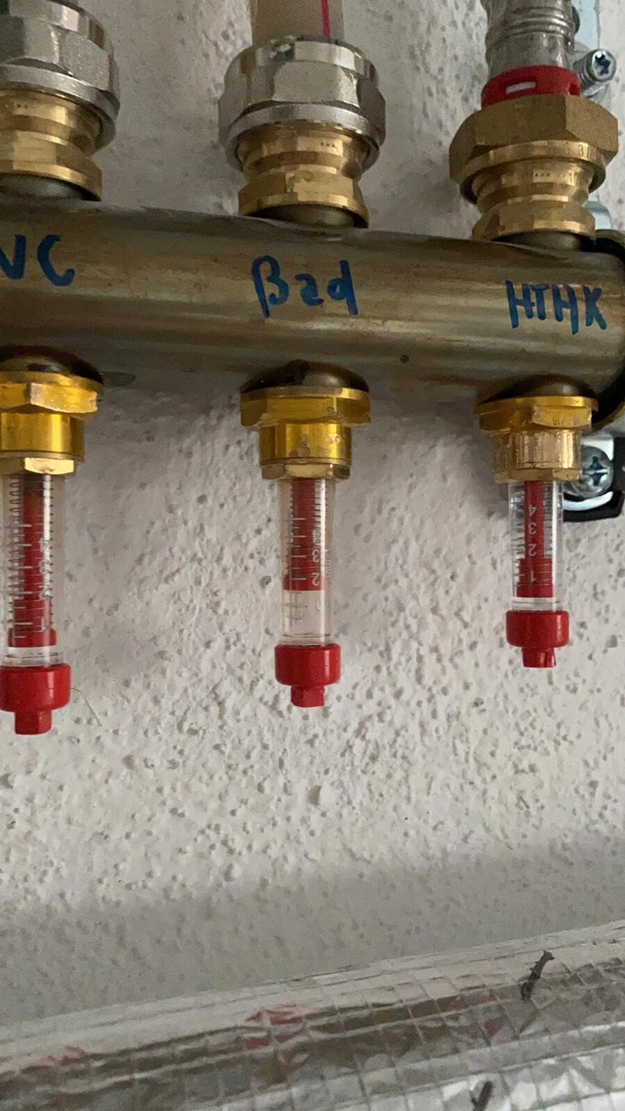 Verteilungsrohr mit drei Absperrventilen und Glasröhrchen mit roter Skala.