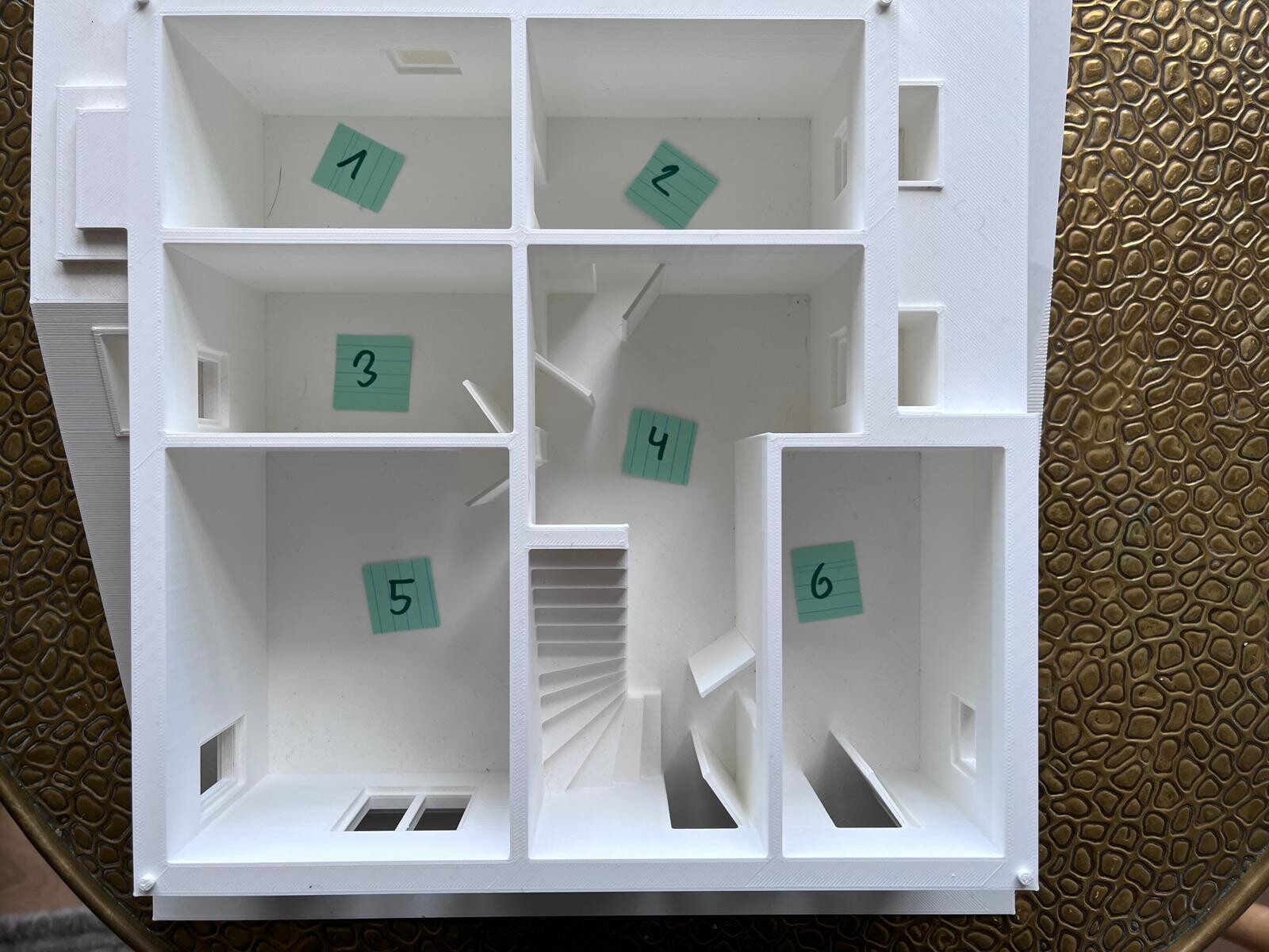 Weißes Modell eines Hausgrundrisses mit sechs Zimmern, nummeriert 1–6 auf grünen Notizzetteln.