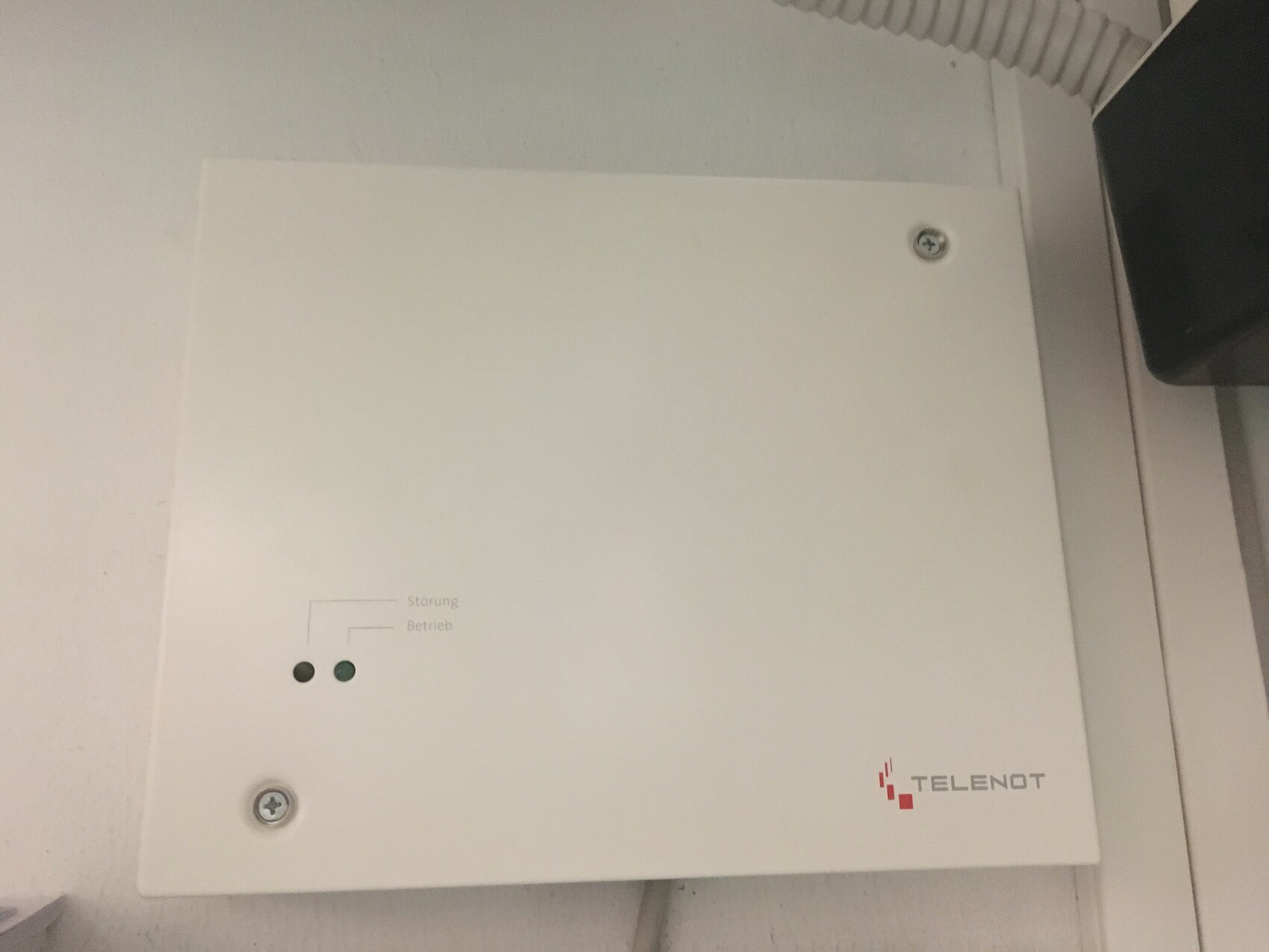 Weiße Metallbox mit zwei LEDs (Störung und Betrieb) und TELENOT-Logo.