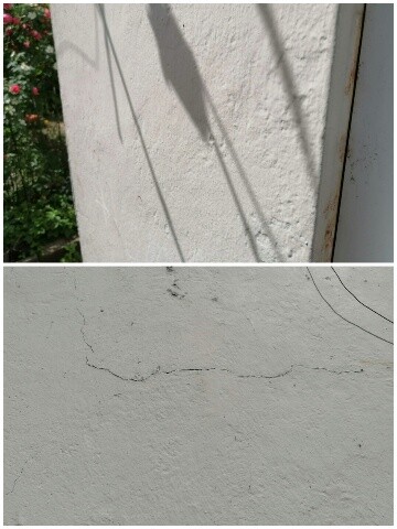 Weiße Außenwand mit Rissen und Schatten von Kabeln