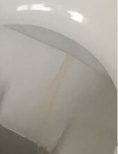 Nahaufnahme einer weißen Badewannenkante mit leichten Verfärbungen.