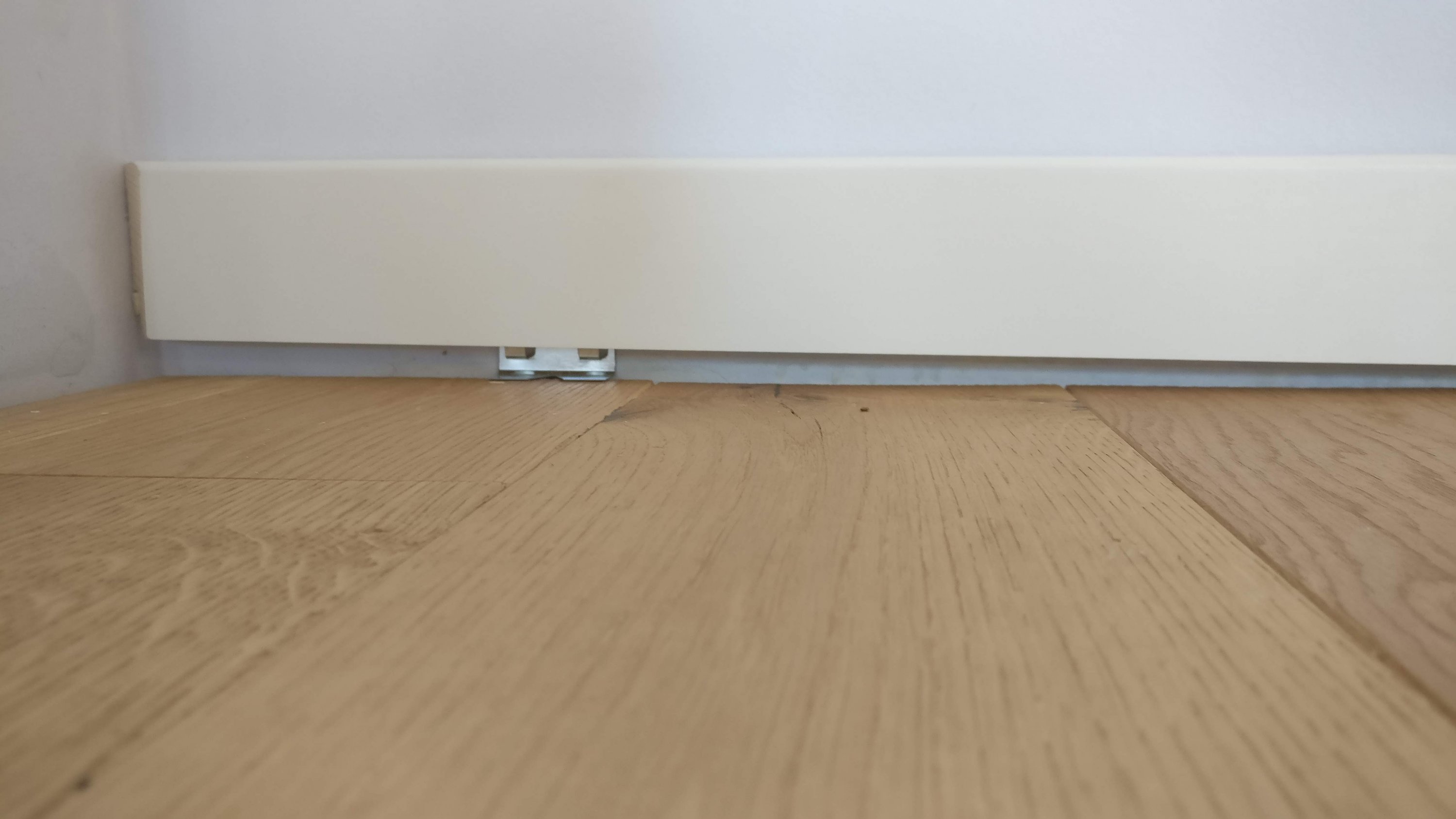 weisse-baseboard-heizung-an-wand-mit-holzboden.jpg