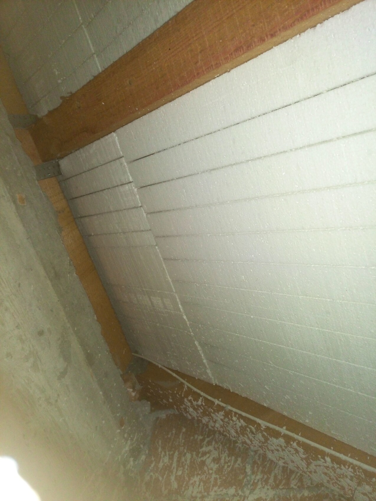 Rohbau-Wanddämmung aus Styroporplatten an einer unbehandelten Wand mit Baustellencharme