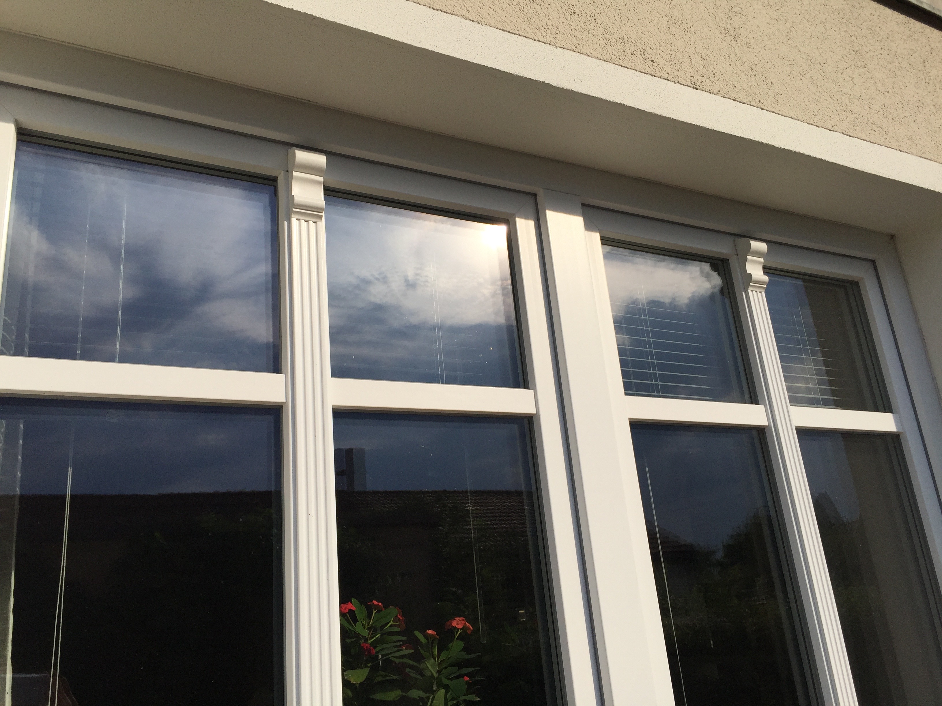 weisse-fensterrahmen-hausfassade-glasfenster-reflexion.JPG