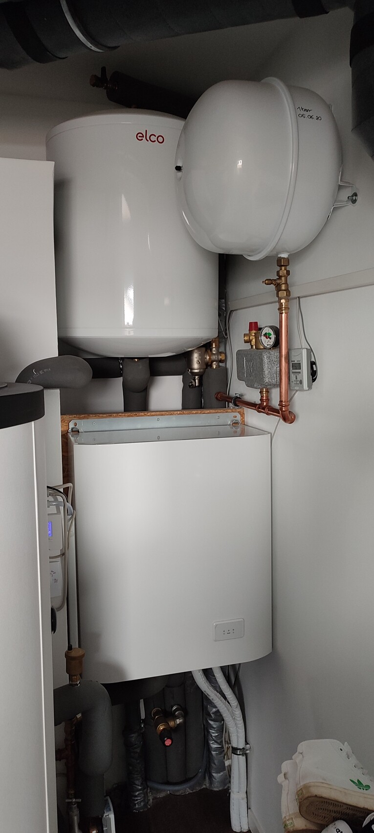Heizkessel mit Ausdehnungsgefäß, Kupferleitungen und Pumpe im Heiztechnikraum.