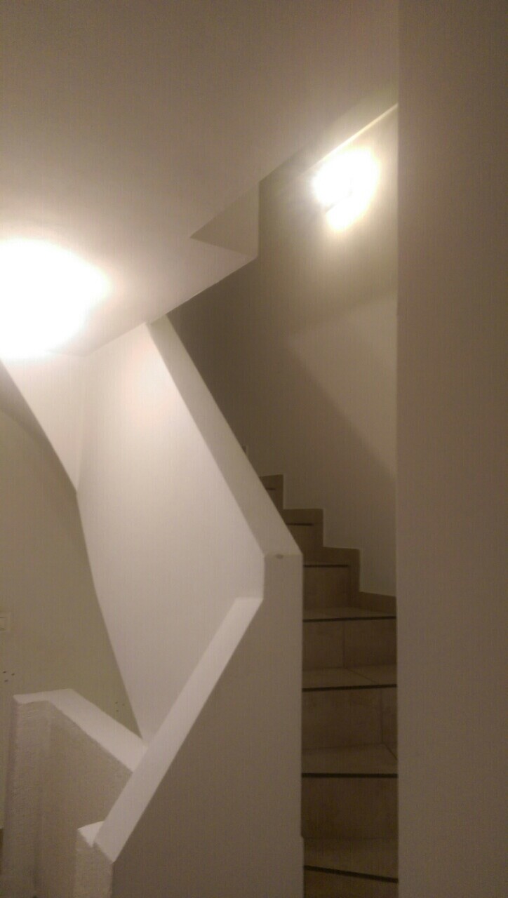 Heller Innenstiegenbereich mit weißen Wänden und Treppenstufen.
