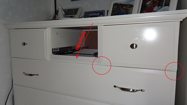 Weisse Kommode mit offener Ablage in der Mitte und Schubladen im Wohnzimmer