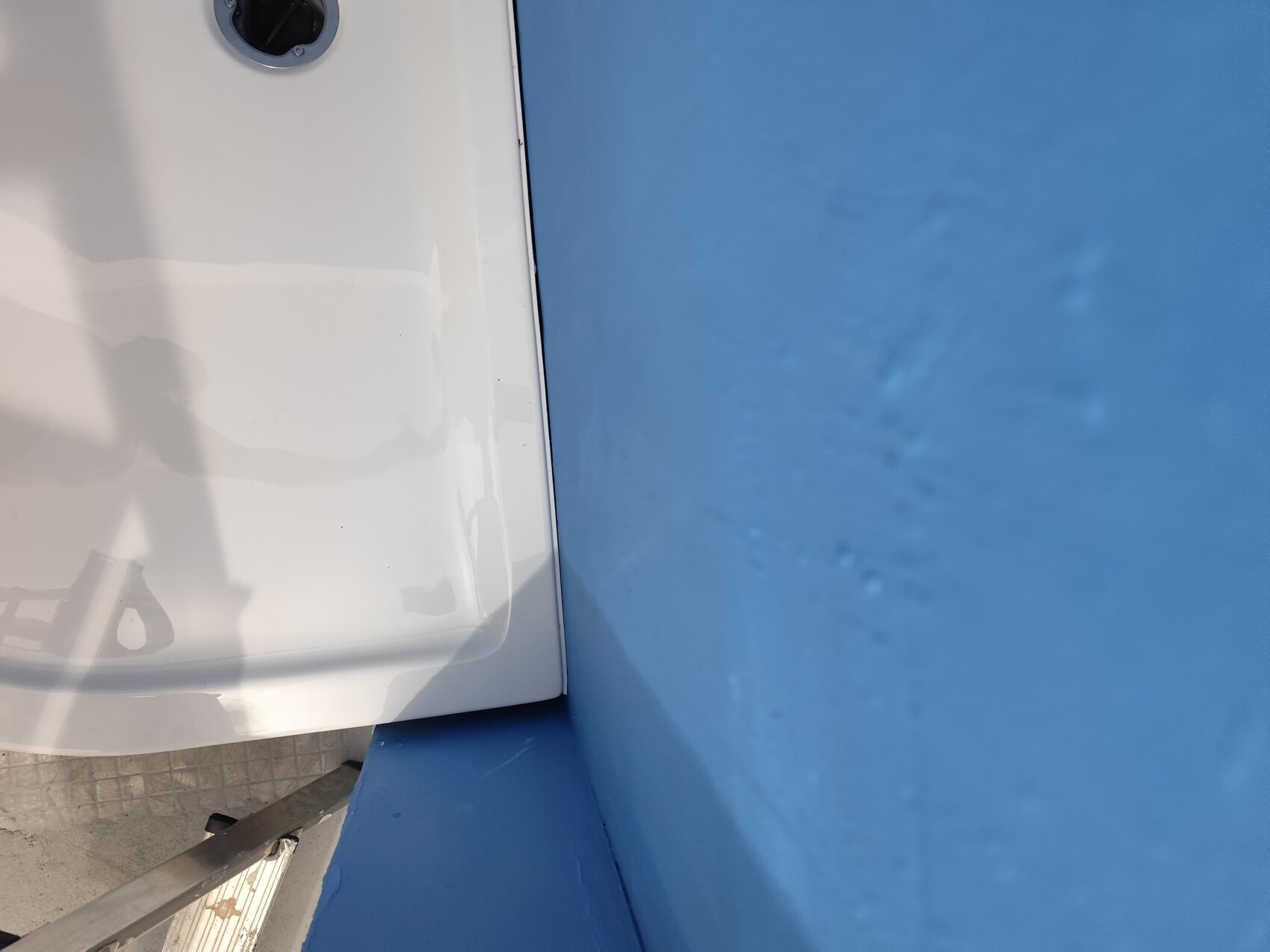 weiße-oberfläche-am-außenbereich-mit-blauer-wand-und-metallleiter.jpg