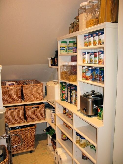 Vorratskammer mit weißen Regalen, Gläsern, Dosen, Körben und Toaster.