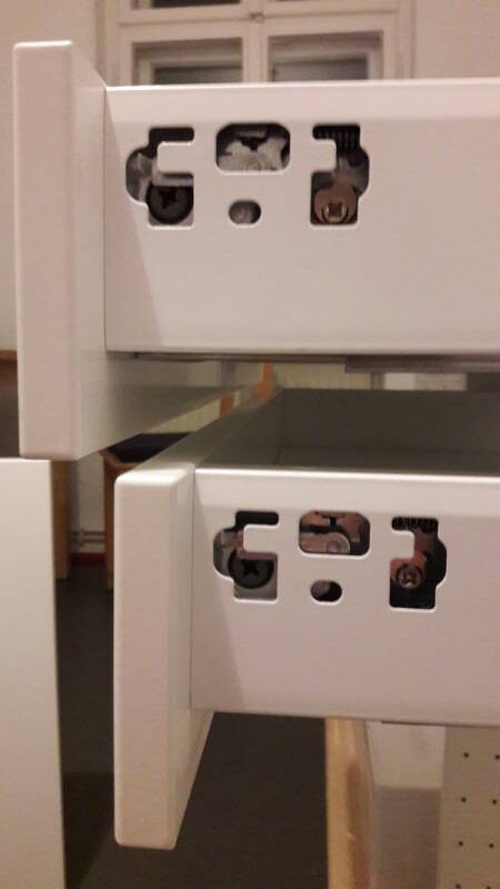 Weiße Schubladenführung und Führungsschienen eines Möbelstücks während der Montage.